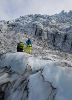 A couple looks towards the immense ice fall on their adventure glacier tour