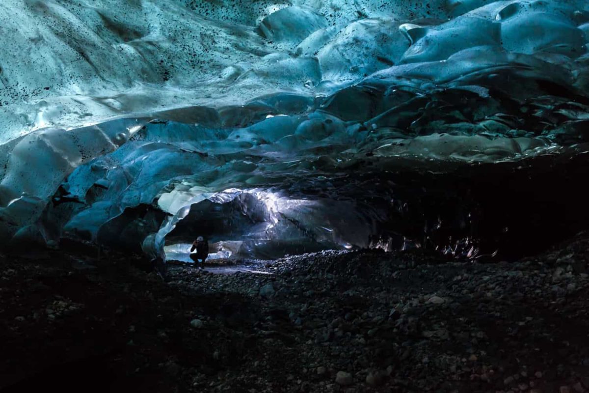 A person photographs blue ice cave that is only reachable by helicopter