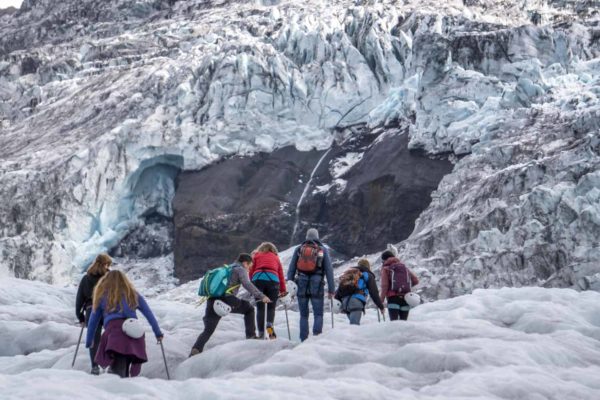 A certified glacier guide leads her group towards the icefall on Falljökull, and outlet of Vatnajökull, Iceland