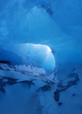 A snow laying on the ground in the blue ice cave