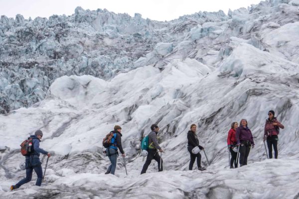 A group stands in the rugged ice terrain on Falljökull outlet glacier, during their glacier adventure.