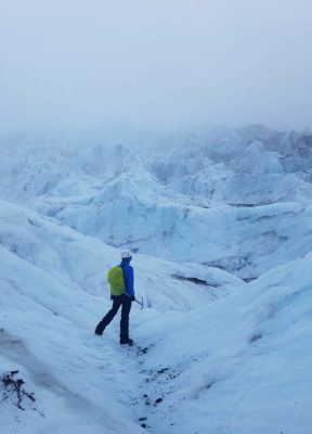 A person on a glacier adventure stands in the partially, mist covered icefall of Falljökull