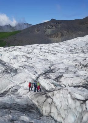 A group stands on the glacier on their glacier adventure