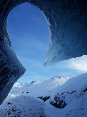 a piece of large blue ice standing out from the top of an ice cave